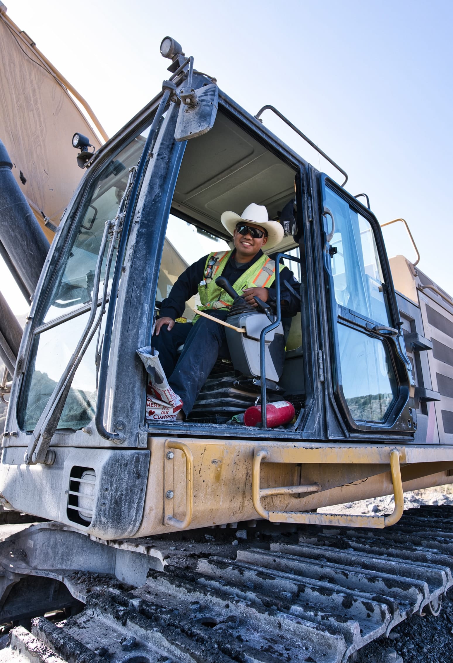 Smiling construction worker sitting in cab of excavator