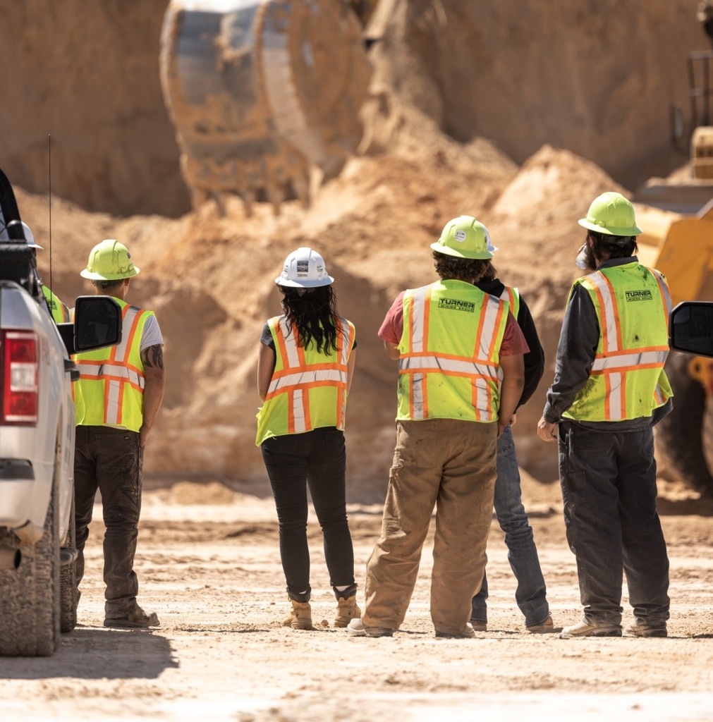 Group of construction workers looking at earthwork